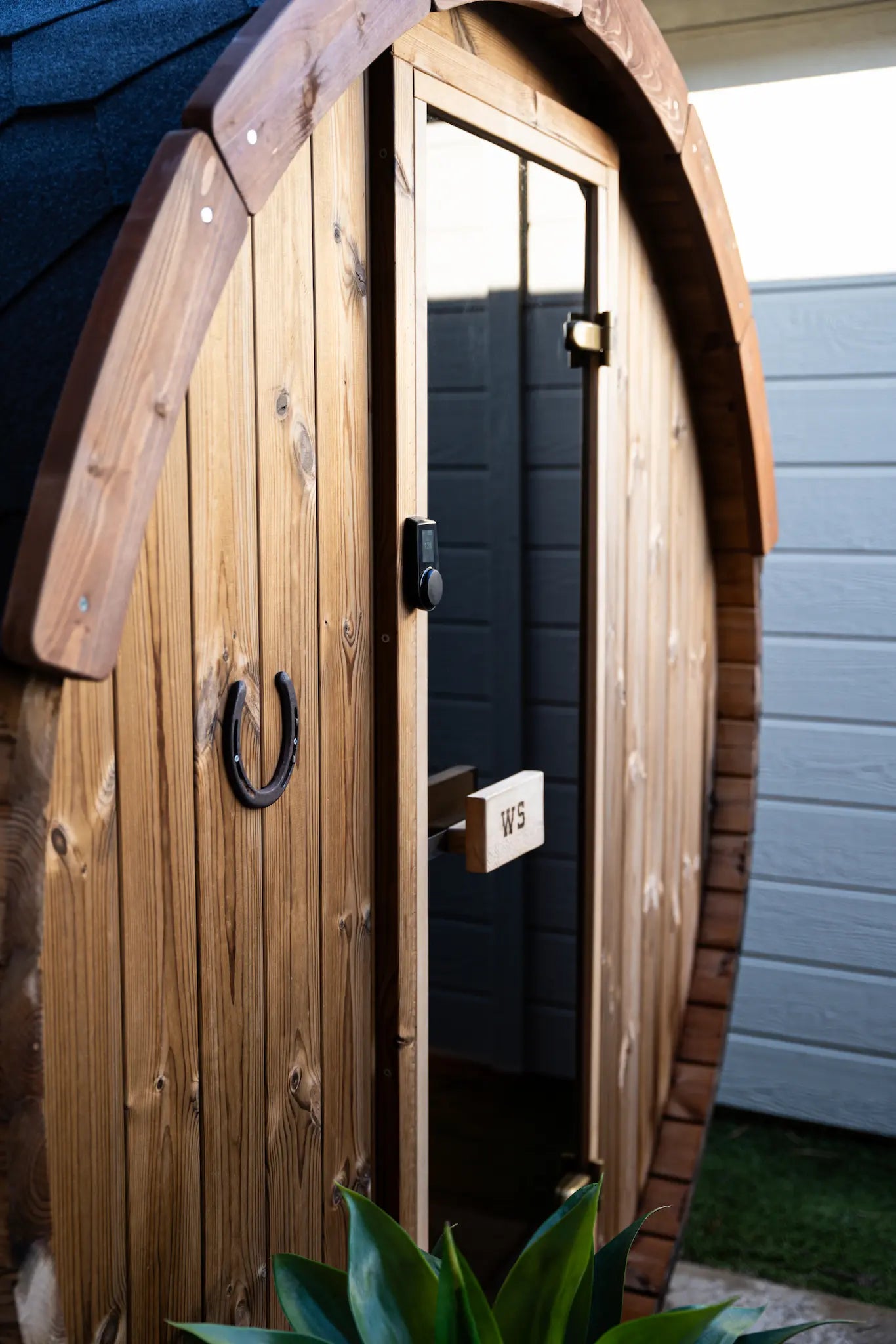 Person carrying wooden slats outdoors with trees and a building in the background.